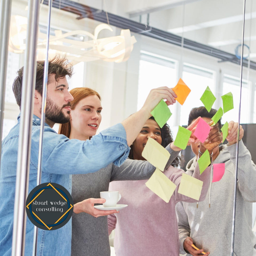 Workshop A group is placing Post-it notes on glass.
